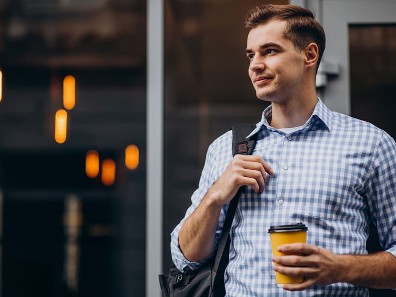 Man outside holding a coffee